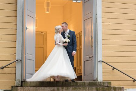 Vihkiparin suudelma kirkon portailla